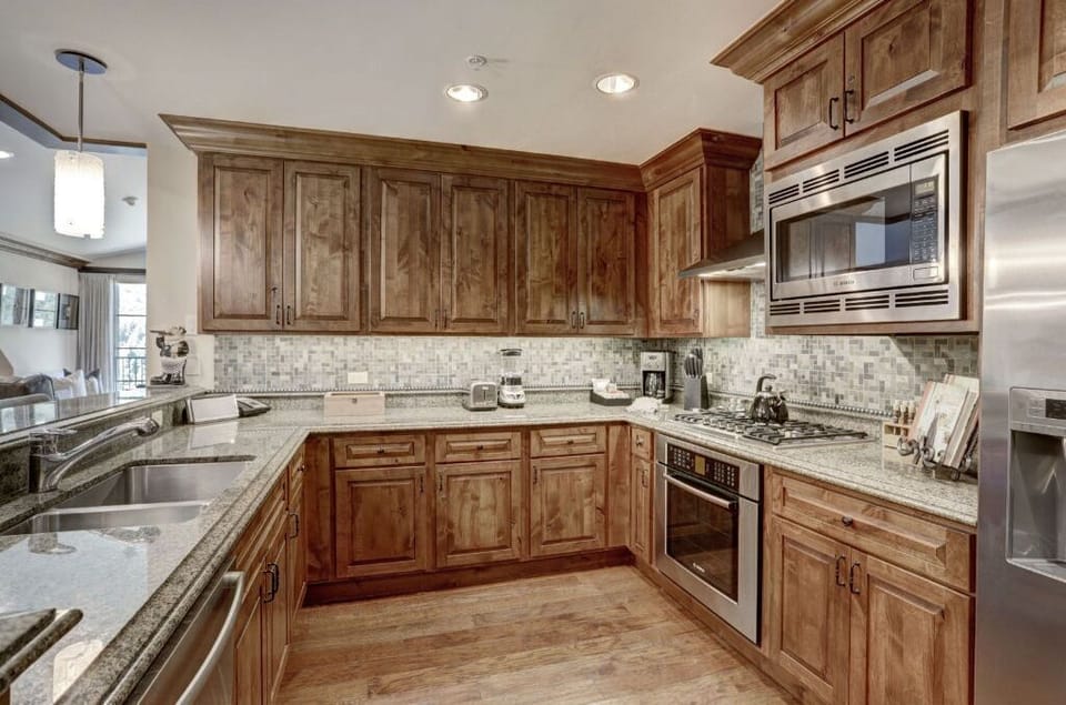 Traditional kitchen with rich wooden cabinetry and modern appliances.
