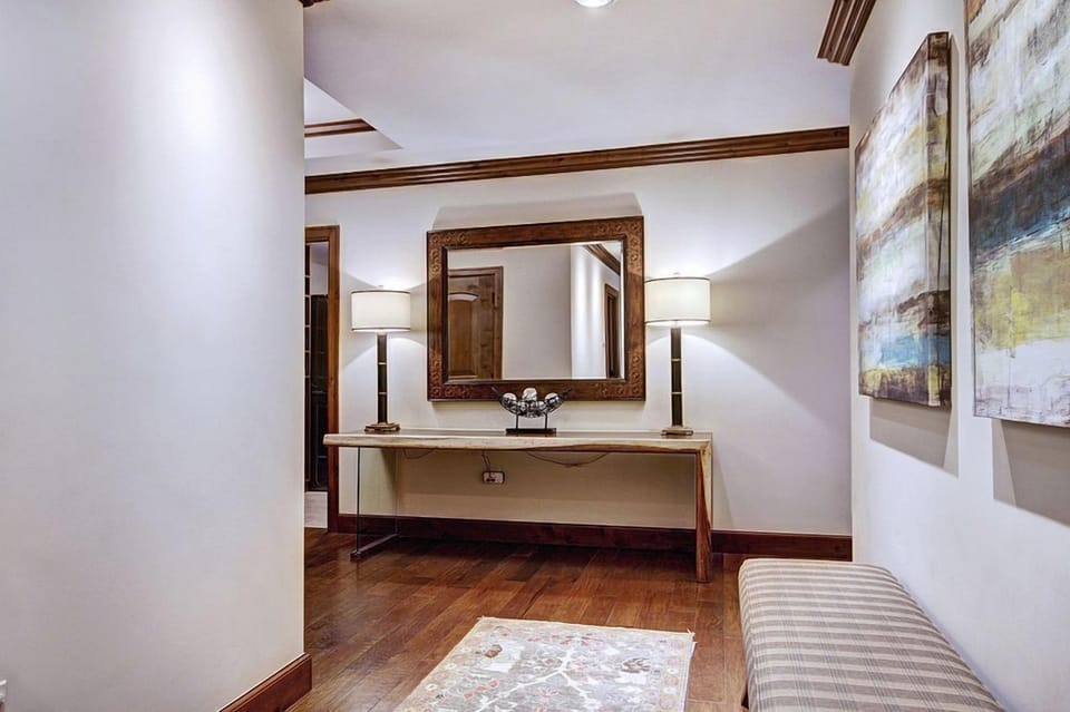 Step into elegance with this inviting foyer, accentuated by modern artwork and warm lighting.