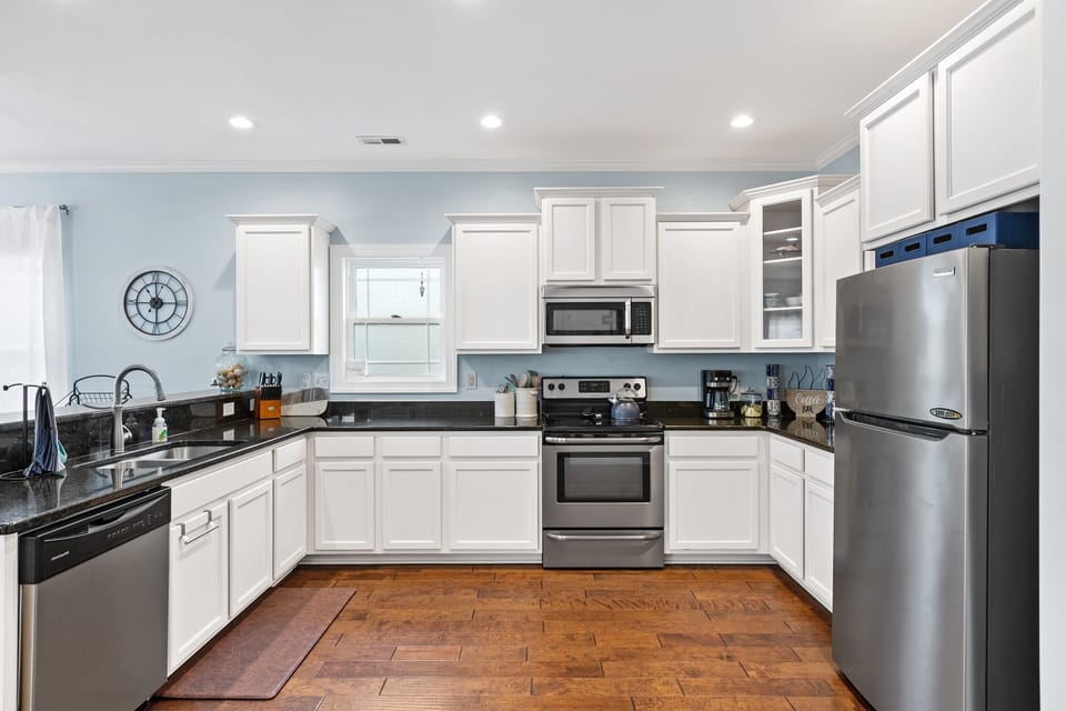 Well-stocked kitchen includes blender, tea kettle, various options for coffee, dishes for adults and kids, and some open pantries for food.
