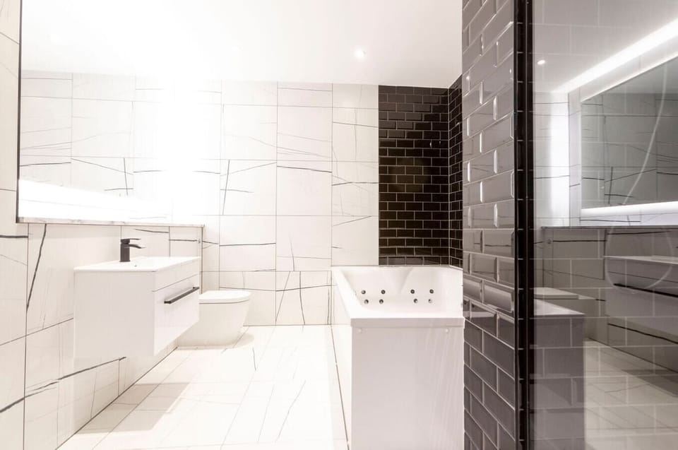 Bathroom with a jacuzzi and a separate shower.