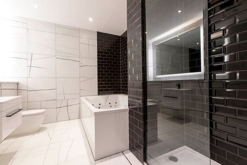 Bathroom with a jacuzzi and a separate shower.