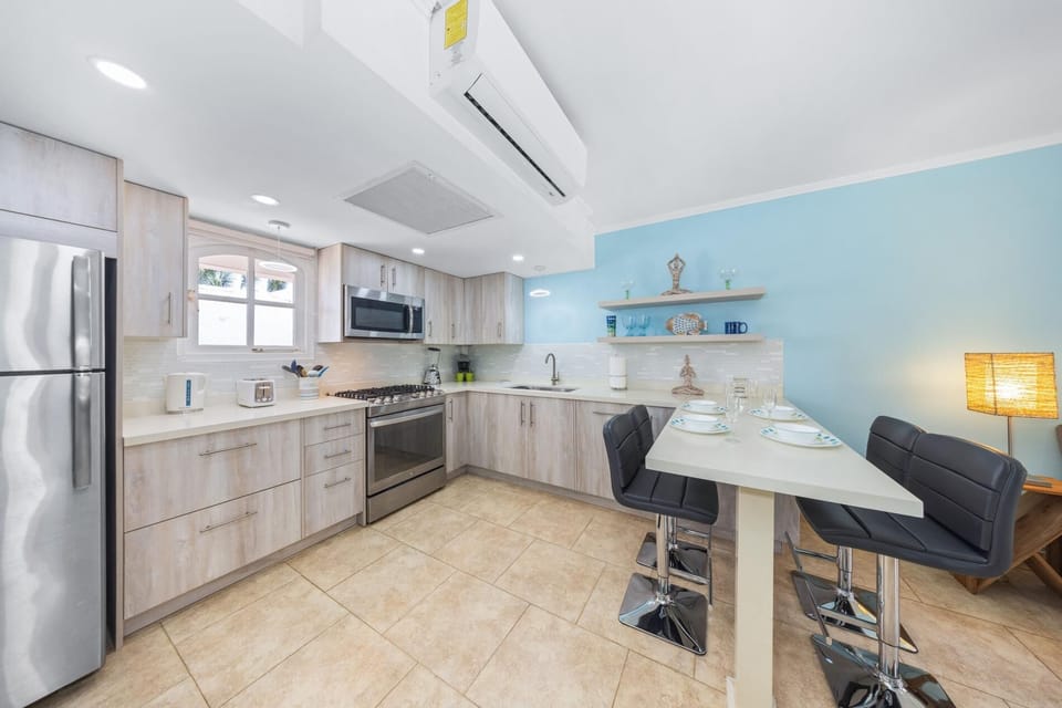 Well-appointed kitchen equipped with a breakfast bar, perfect for casual dining, and a complete set of appliances, including a refrigerator and stove to make mealtime a pleasur