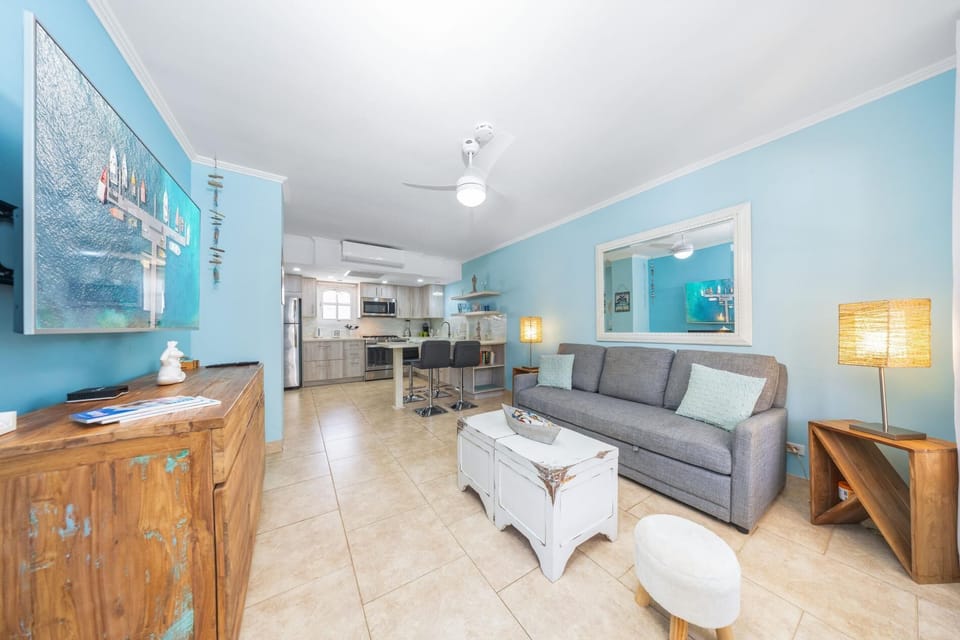 unwind in comfort and style in our cozy living area, boasting a soft sofa, flat-screen TV, and plenty of natural light, perfect for a relaxing evening in or a fun night of entertainment