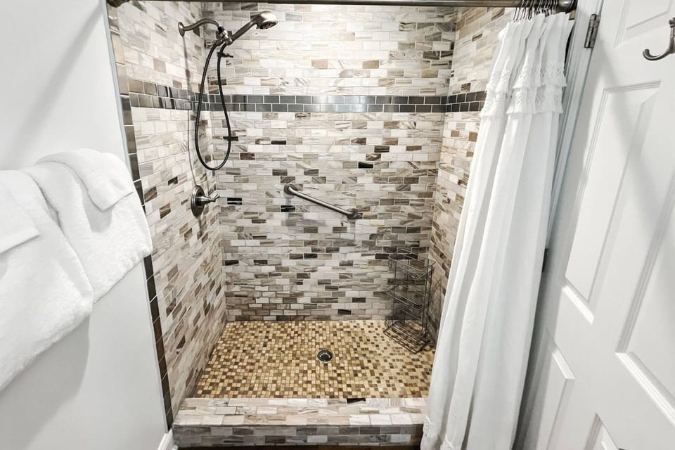 Spacious tiled shower in main bathroom
