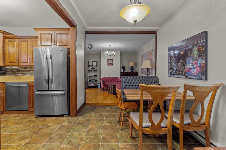 The breakfast nook offers a cozy spot for casual dining, with a view into the living room. The combination of wooden and leather seating creates a warm, inviting atmosphere for morning coffee or informal meals.