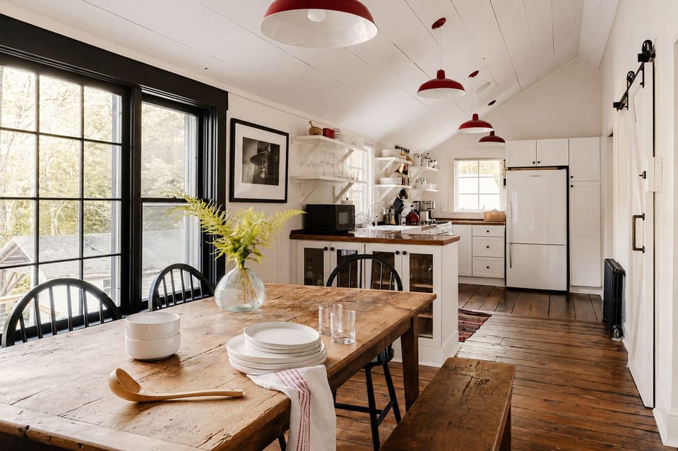 Grab bowls and plates from the table setup and pass them down for serving. The kitchen island just past the table keeps the microwave and stove close by, so you are not walking far to plate the food.