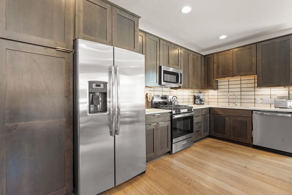Whip up your favorite meals in a spacious, fully equipped kitchen with modern appliances, sleek gray cabinetry, and plenty of counter space for all your culinary needs.