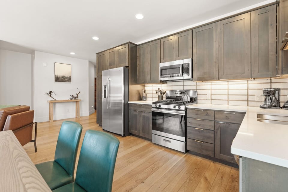 Step into your spacious kitchen featuring stainless steel appliances, warm wood cabinetry, and an open layout that flows into the dining and living areas—perfect for preparing meals and gathering together.