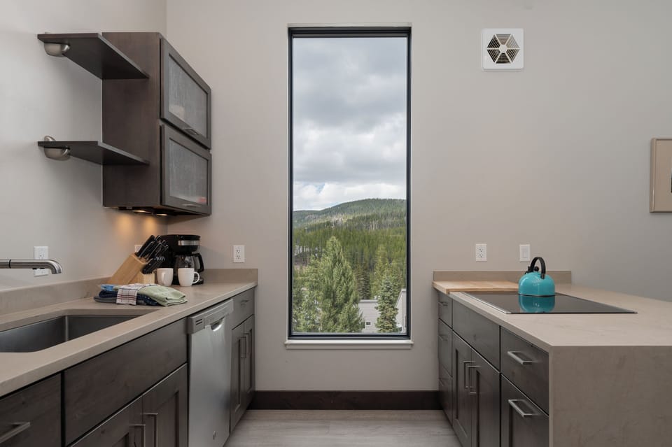 - Kitchen with wide window framing stunning mountain scenery   - Fully equipped with modern appliances and essentials   - Functional layout designed for cooking with a view