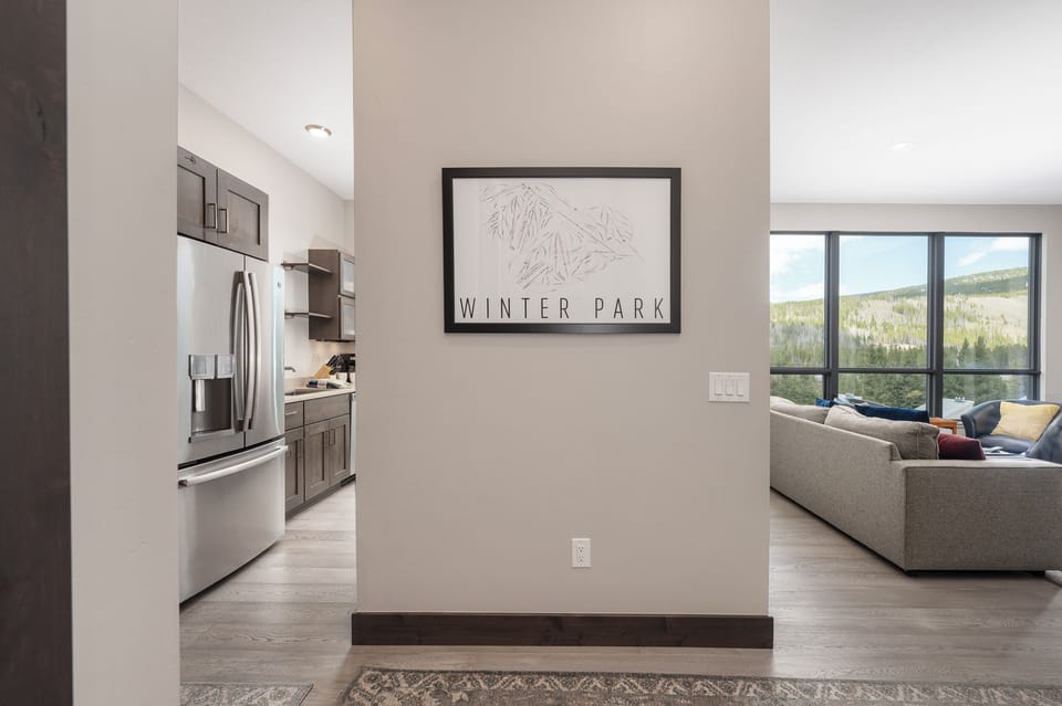 - Wall art with Winter Park design adds local touch   - Hallway connects open kitchen to bright living area   - Modern layout with mountain inspired details