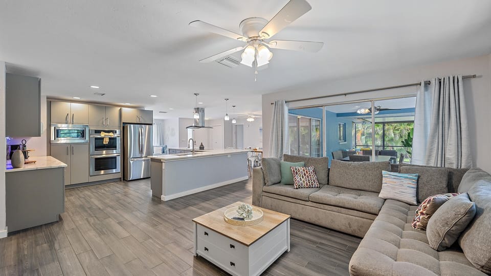 Large cozy sectional in the living room with open floor plan and access to kitchen and dining areas.