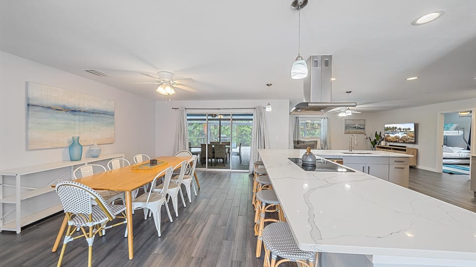 Open concept kitchen and dining with access to private backyard screened-in patio with swimming pool.