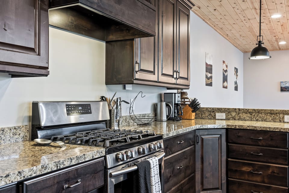 - Modern kitchen with granite countertops  
- Stainless steel gas range and full appliances  
- Dark wood cabinets provide rustic mountain feel