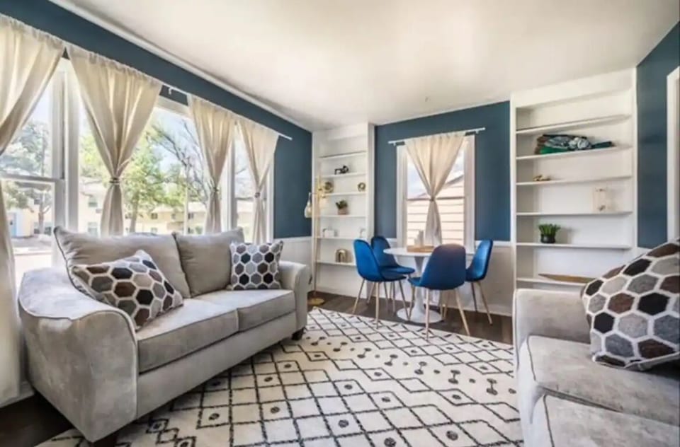 The upstairs living room with two comfy couches, smart TV, AC unit, dining table
