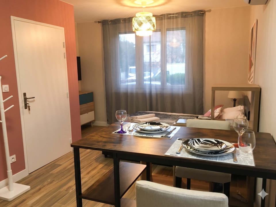 Coin repas avec table haute, tabourets et ambiance chaleureuse le soir