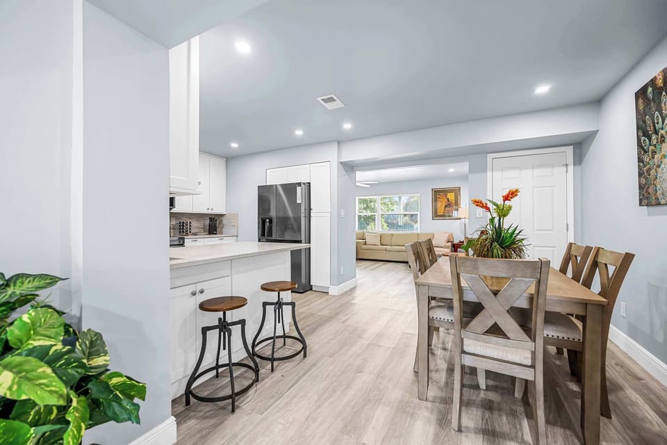 Open-concept kitchen and dining area with modern lighting and natural wood flooring.