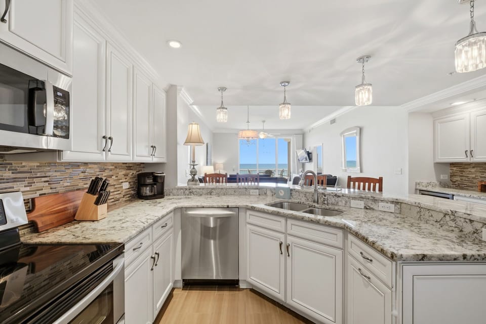 Step into this bright chef's kitchen with granite counters, elegant pendant lighting, and stunning ocean views that stretch across the horizon from every angle.