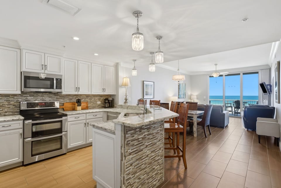 This open-concept space blends your vacation kitchen, dining, and living areas with stunning ocean views. Cook gourmet meals with modern appliances, share stories around the island, and unwind in style.