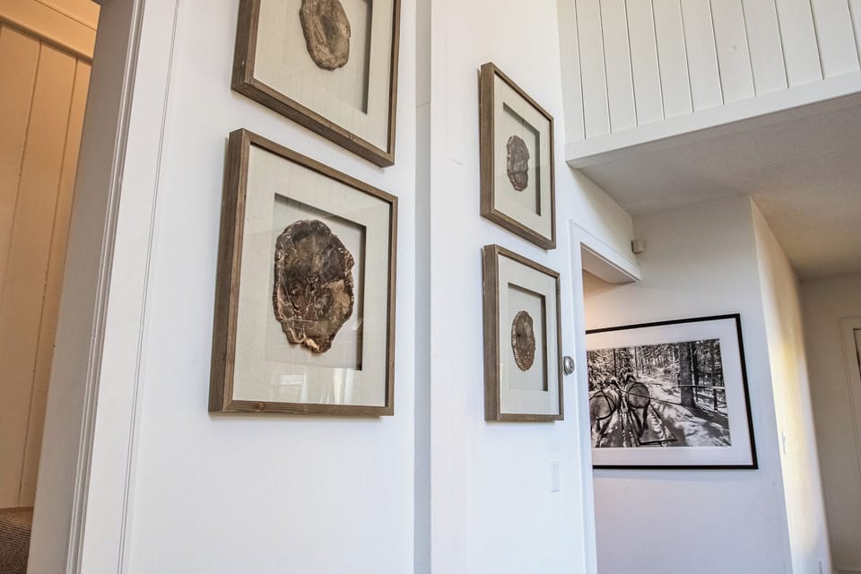 - Artistic hallway showcasing nature-inspired framed wall art   - Bright airy design connects living area to cozy private bedrooms   - Sophisticated rustic touches enhance the modern mountain retreat