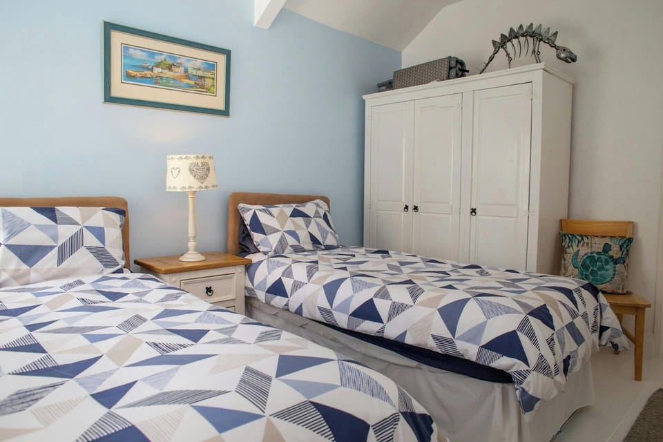 Twin bedroom with wardrobe, bedside drawers with a lamp