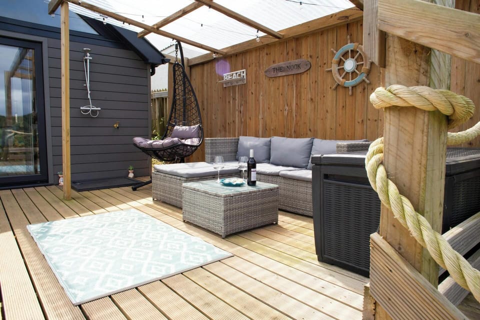 Deck area with hanging chair and rattan effect sofas and table