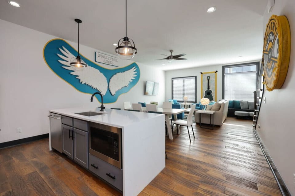 Kitchen island opens to the living space beneath a signature mural.