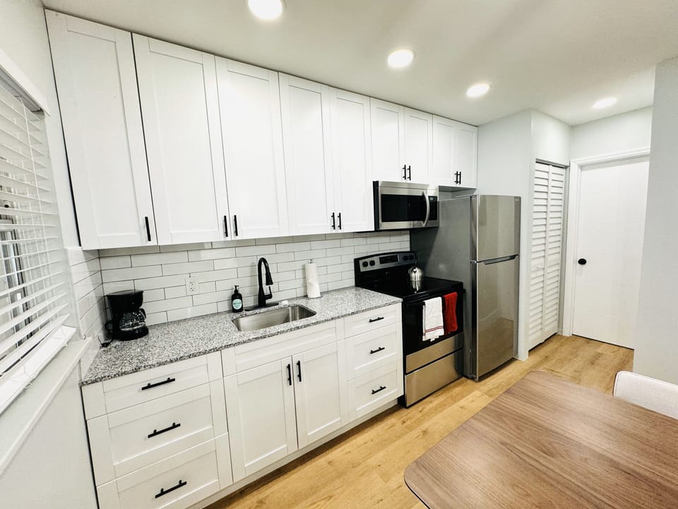 Welcome to your modern kitchen with sleek countertops, stainless-steel appliances, and ample storage. Natural light enhances the warm ambiance, creating a versatile and inviting space for all your culinary endeavors.