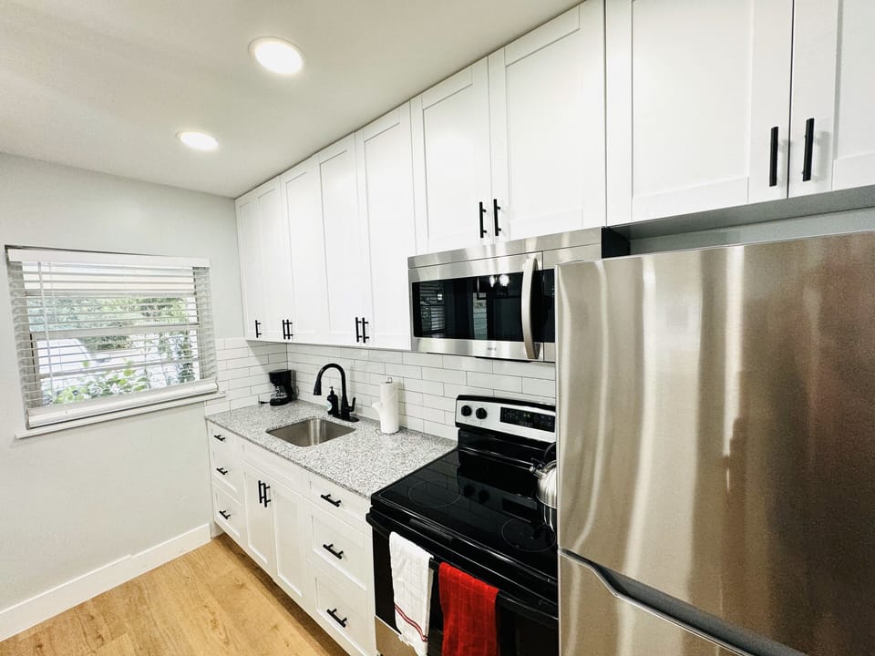 Welcome to your modern kitchen with sleek countertops, stainless-steel appliances, and ample storage. Natural light enhances the warm ambiance, creating a versatile and inviting space for all your culinary endeavors.