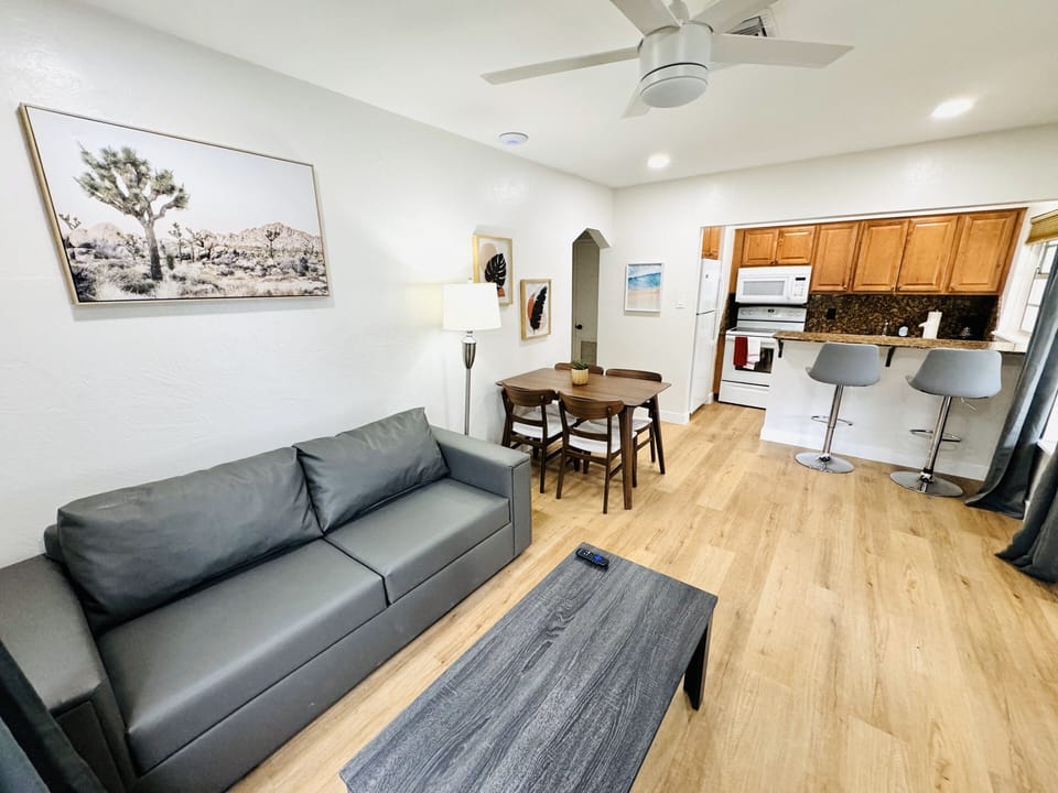 Welcome to your comfortable living room retreat, featuring a plush couch. The inviting ambiance is complemented by a practical coffee table, offering a convenient surface for your essentials. A smart TV provides endless entertainment possibilities.