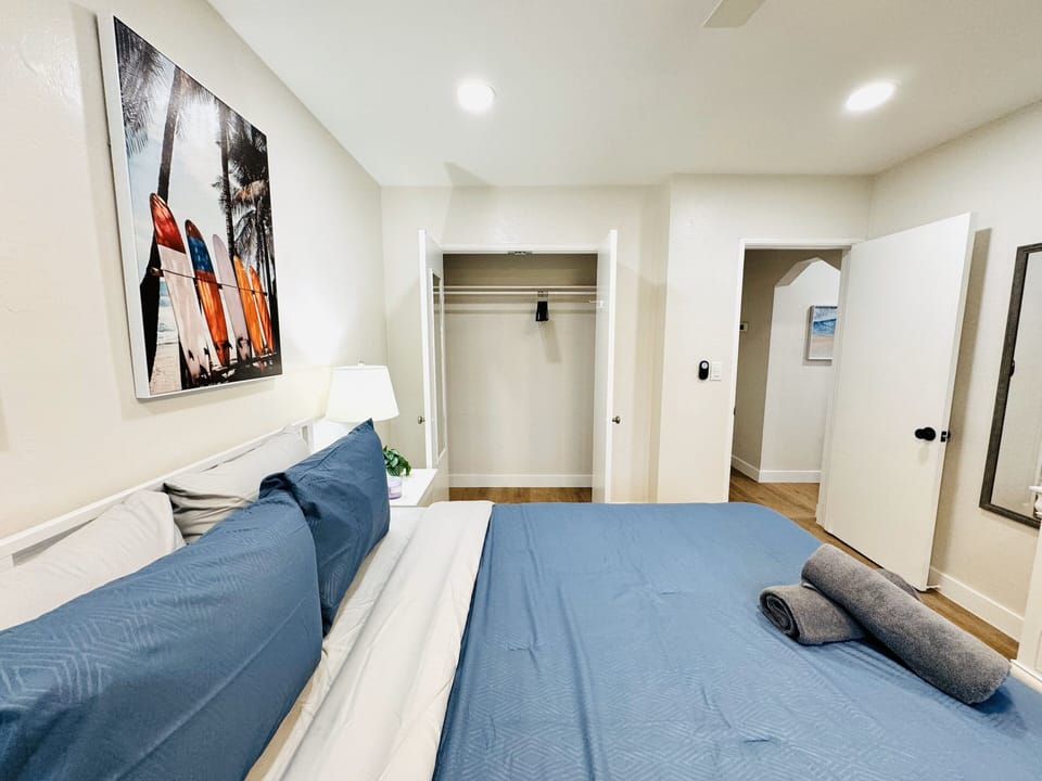 Enter our cozy bedroom setup, featuring a roomy king-size bed and a practical smart TV for your entertainment needs. The simplicity of the space ensures a comfortable atmosphere, making it a laid-back retreat after a long day.