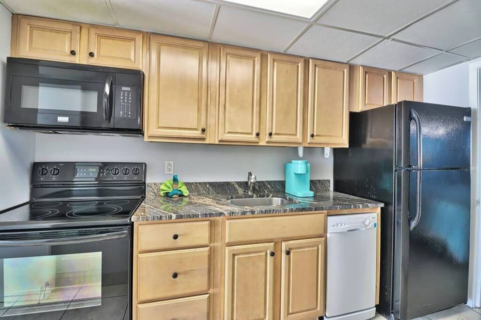 a kitchen with a fridge, microwave, dishwasher, stove, and oven.