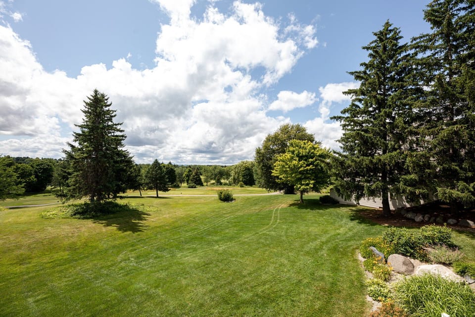Open green fairways under wide blue skies, perfect for a scenic stroll.