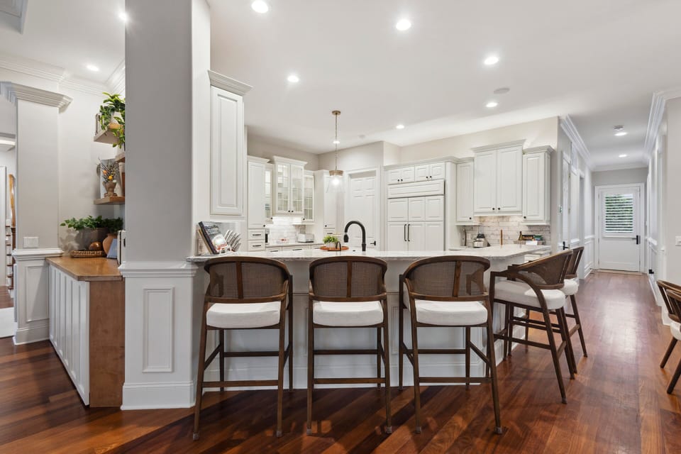 Its open-plan layout transforms mealtime into a joyous occasion, offering ample seating at the island and adjacent dining tables.