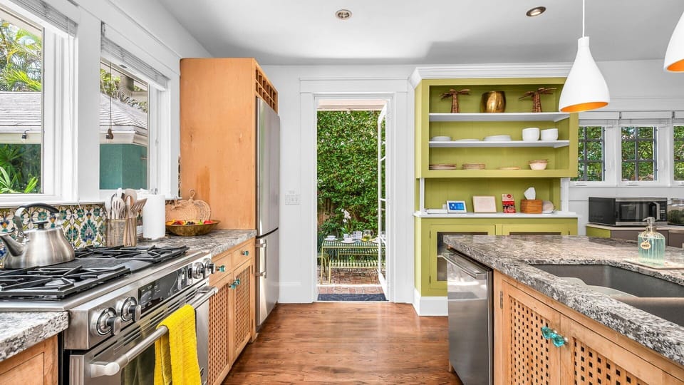 This fully equipped kitchen features a gas range stove, Nespresso, Keurig, and drip coffee makers, plus a blender and serviceware for 10. French doors lead directly to the patio with an outdoor dining table for 6—perfect for al fresco meals in paradise.