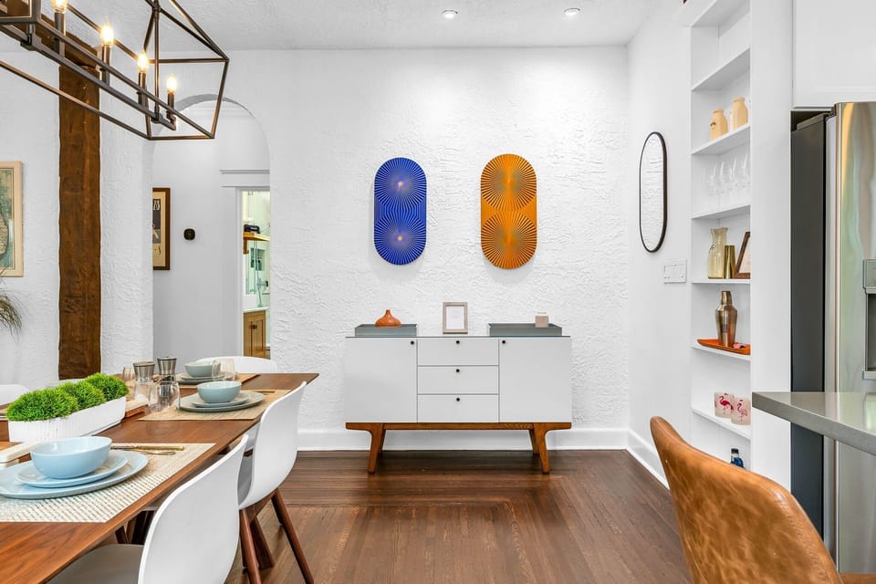 Enjoy a mid-century dining experience under an elegant chandelier, featuring a table for s6, 3 bar stools, and an outdoor set for 6 Classic elegance meets modern comfort.