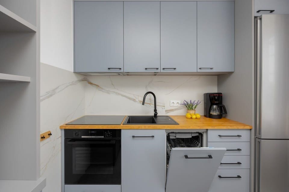A sleek kitchen with modern grey cabinetry and integrated appliances. Practical and stylish cooking space.