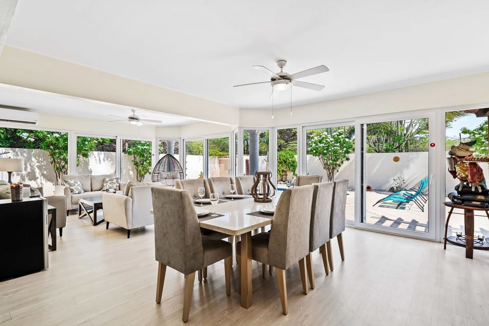 Gather around the elegant dining table, perfect for sharing meals and making memories - Dine in style in a spacious area designed for 8 persons - Enjoy meals in a bright and airy atmosphere with panoramic windows and pool views