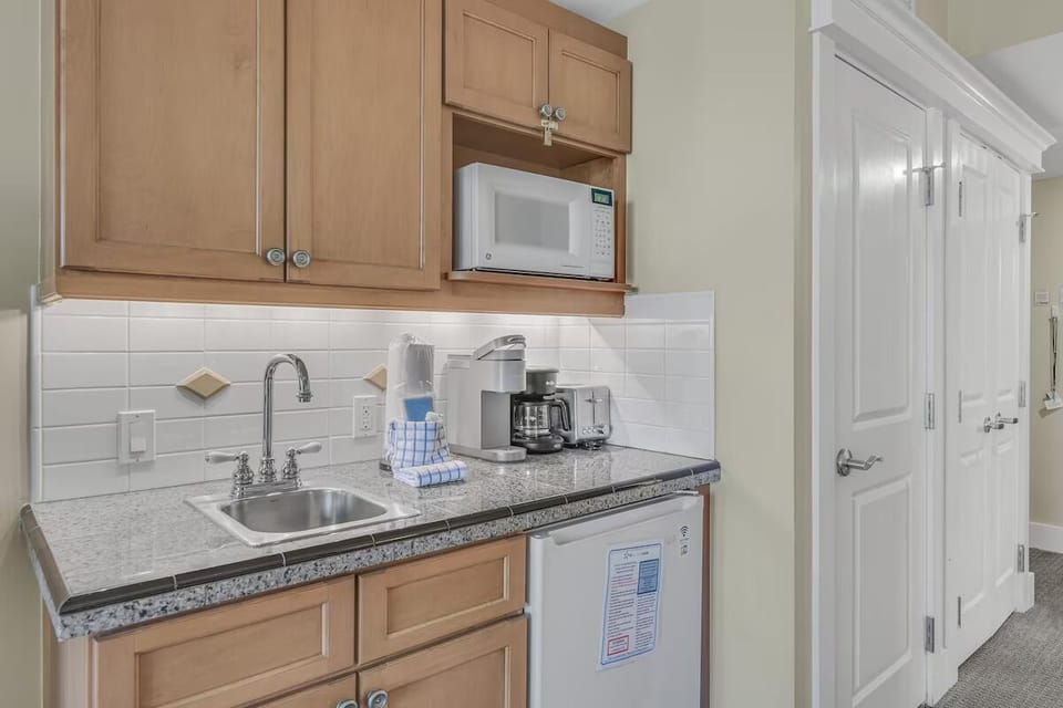Compact kitchenette with granite counters, microwave, mini fridge, and everything needed for easy meals and beach-day snacks.