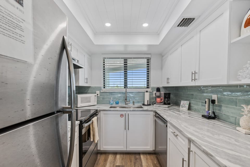 The beautifully updated kitchen, complete with granite countertops, stainless steel appliances, and essential cooking tools—including a standard and Keurig coffee maker, toaster, and microwave—ensures you have everything you need.