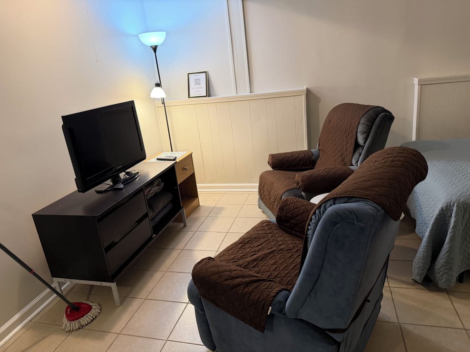 Ground floor Family room with TV, chairs and 2 full b