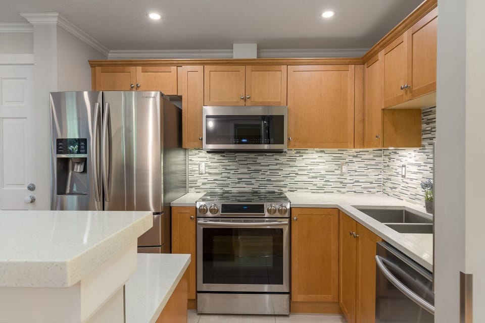 A sleek, fully equipped kitchen with stainless steel appliances makes cooking a breeze.