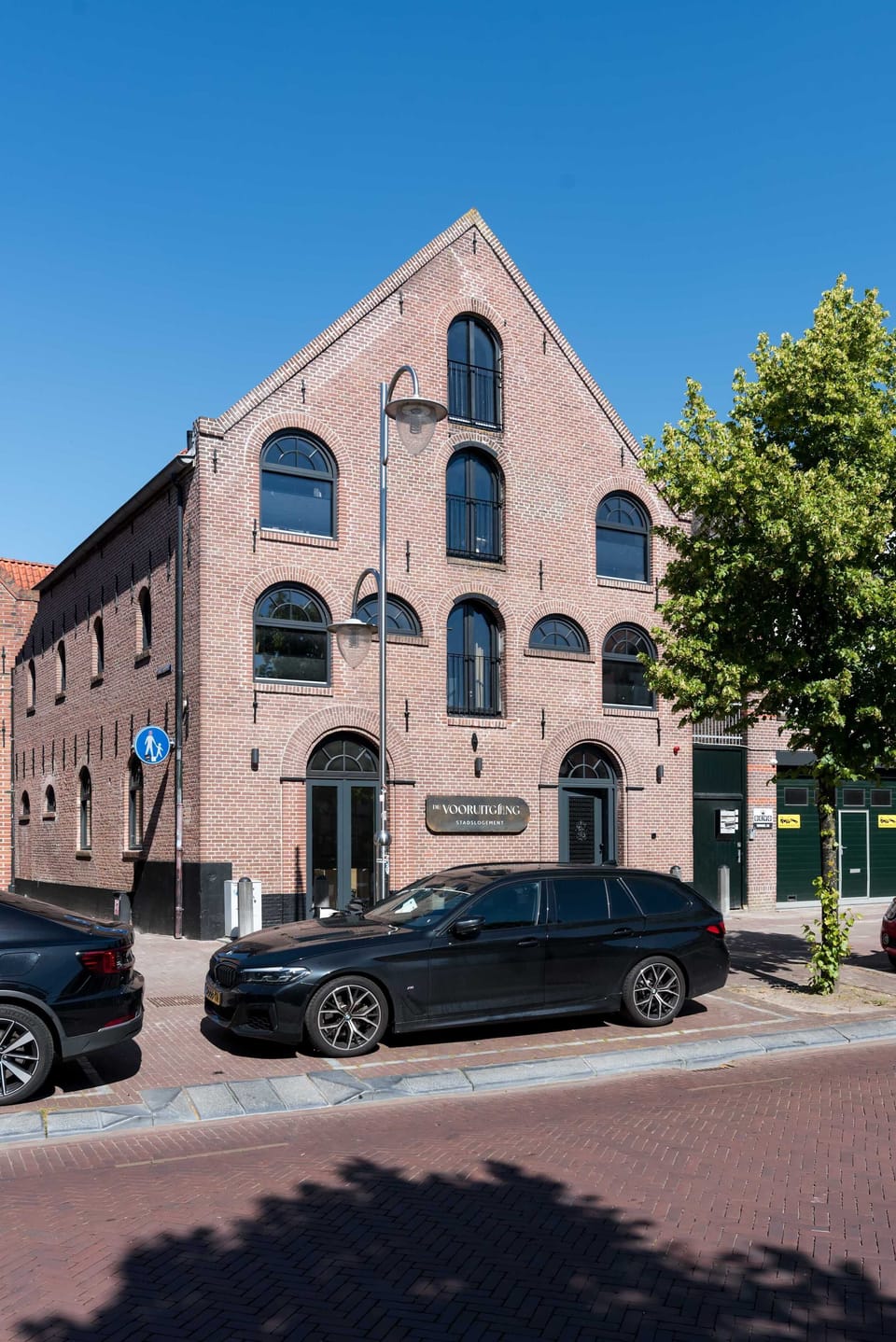 Other angle of the front of the building, showing alley on the side and windows on the facade