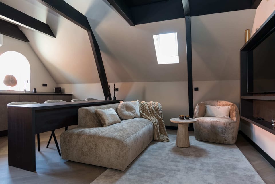 Living room with comfortable sofa and lounge chair, and cable TV