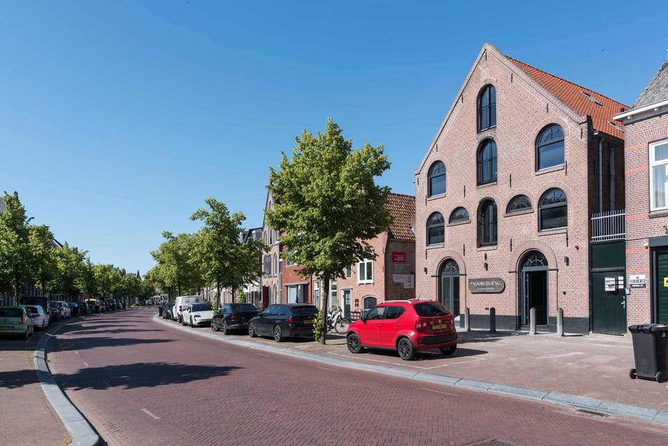 Front of the building with street and pavement, parking