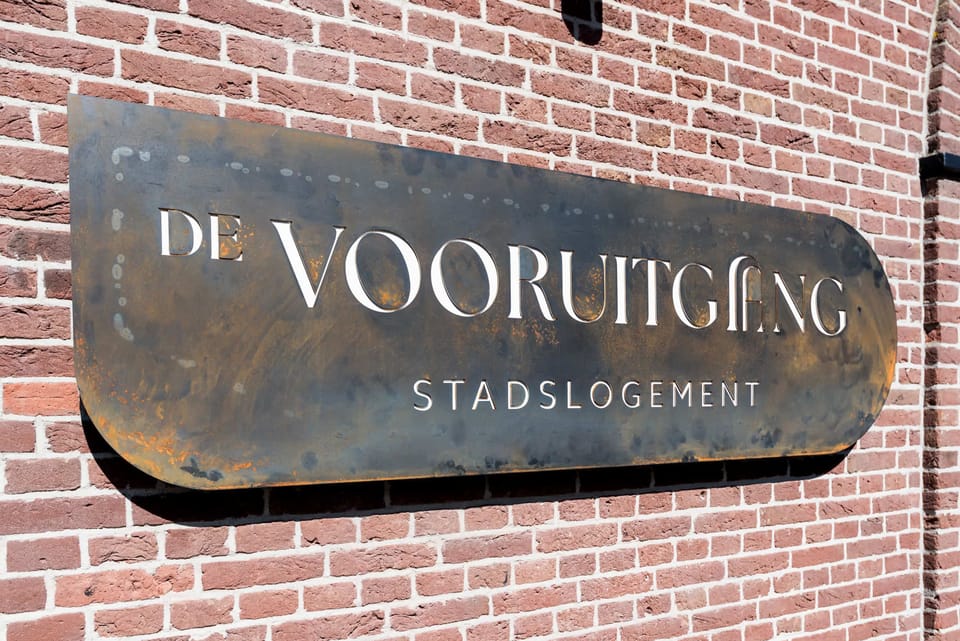 Plaque on the front of the building "De Vooruitgang Stadslogement"