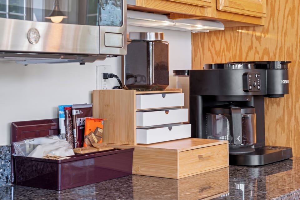 Start your mornings with ease in this well-equipped coffee station, featuring a Keurig coffee maker, ample storage for snacks and coffee essentials, and everything you need for a cozy breakfast.