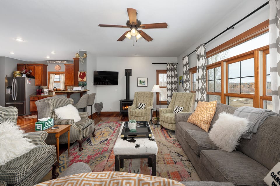 Sink into plush sofas and chairs around the cozy fireplace, where natural light streams through windows and thoughtful details create your perfect mountain retreat.