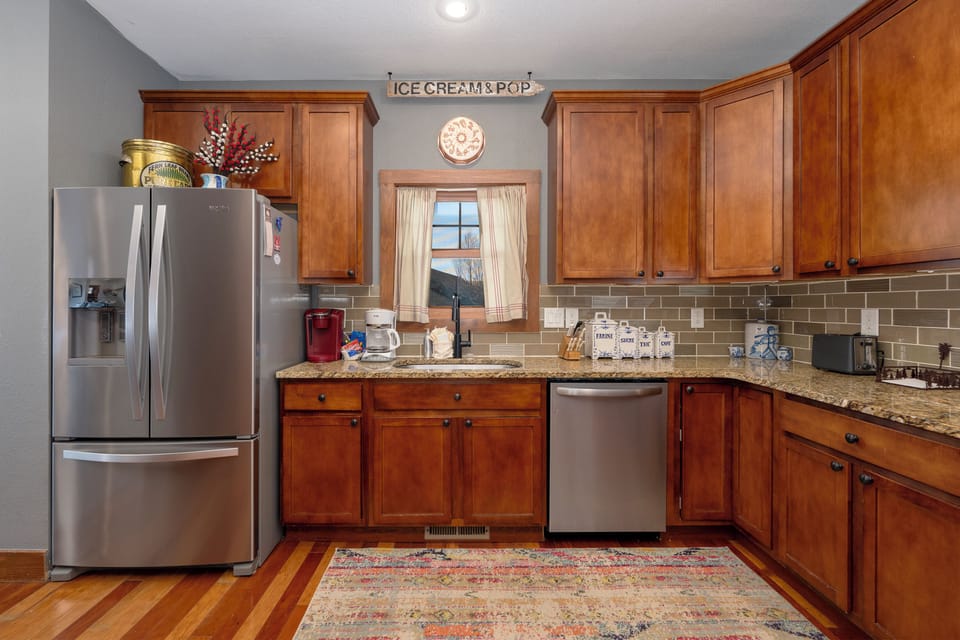 Whip up your favorite meals in this fully-equipped kitchen featuring rich wood cabinets, granite counters, and modern stainless appliances.