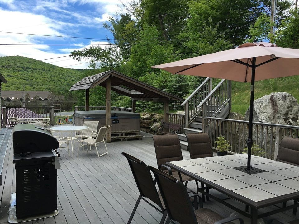 Our oversized back deck w/ hot tub, grill, and patio seating