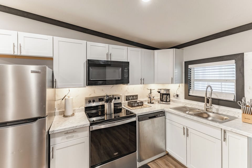 Full kitchen with brand new, stainless steel appliances.